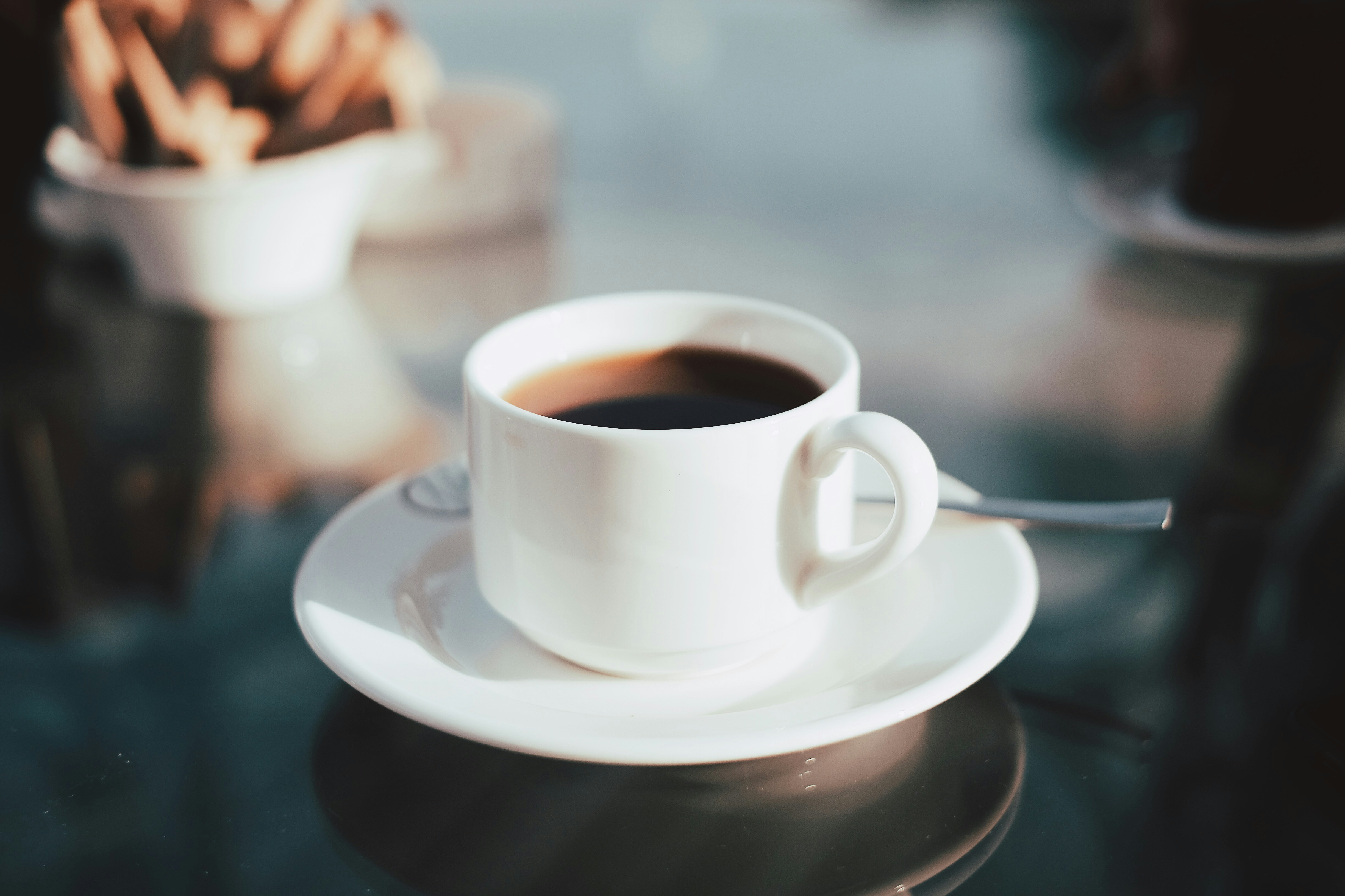 Coffee cup with spoon on glass table
